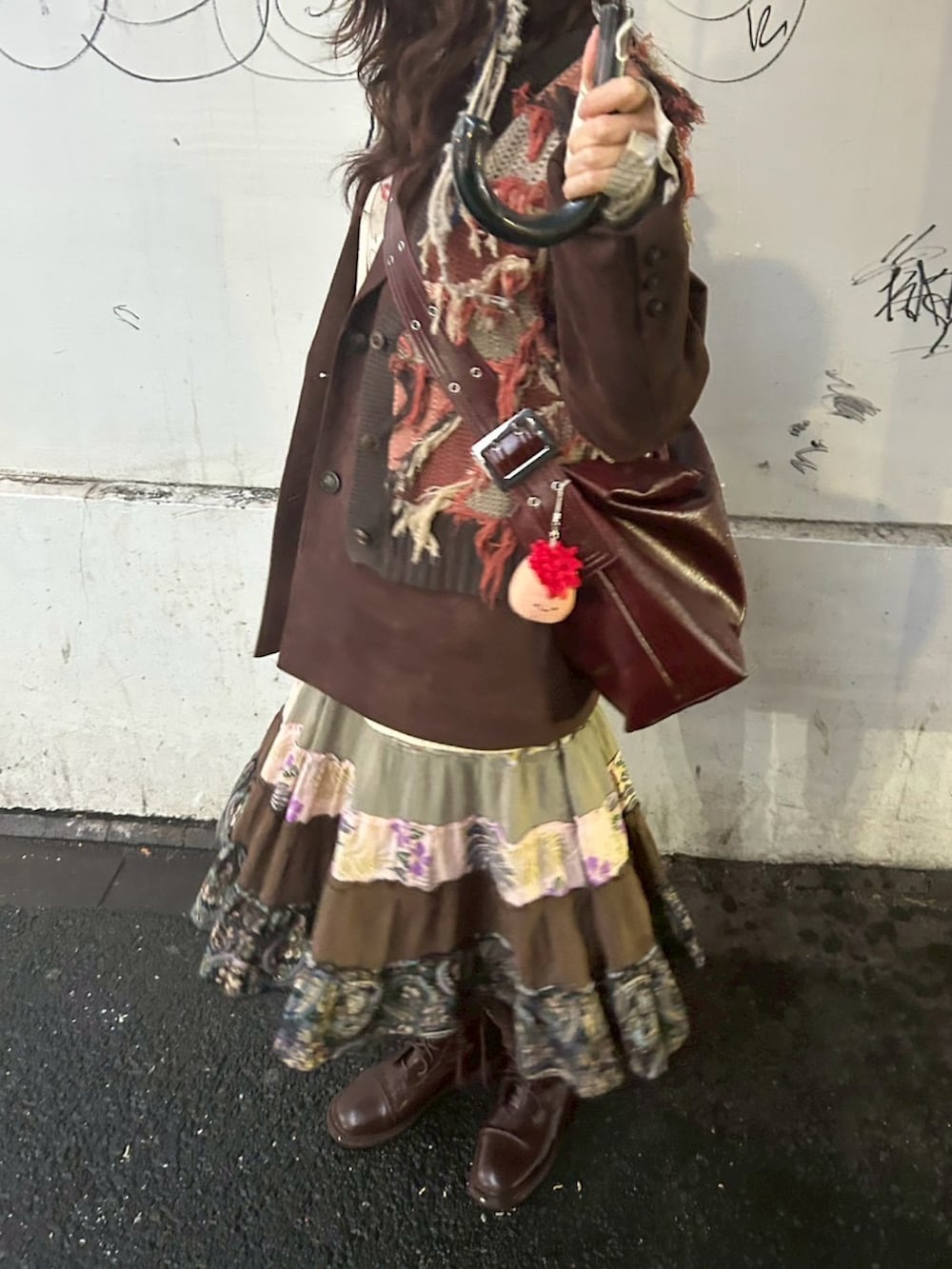 ブラウン系のベスト、ブラウン系のテーラードジャケット、ベージュ系のベストを着用したレディースの春コーディネートの3枚目の写真