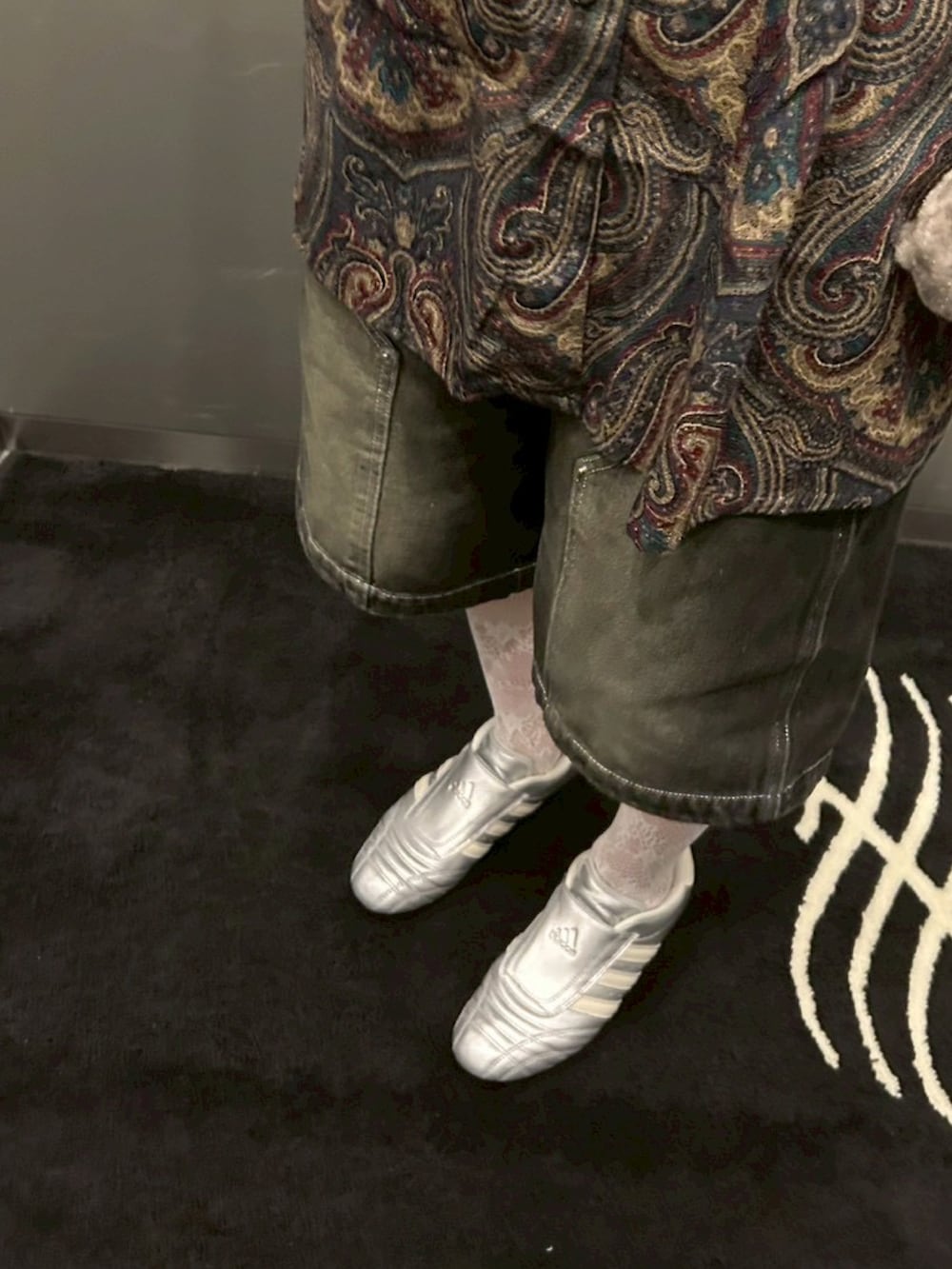 シルバー系のスニーカー、ブラック系のデニムパンツ、シルバー系のその他トップスを着用したレディースの春コーディネートの4枚目の写真