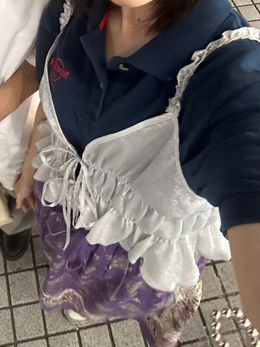 パープル系のスニーカー、シルバー系のキャミソール、ブルー系のポロシャツを着用したレディースの夏コーディネートの3枚目の写真