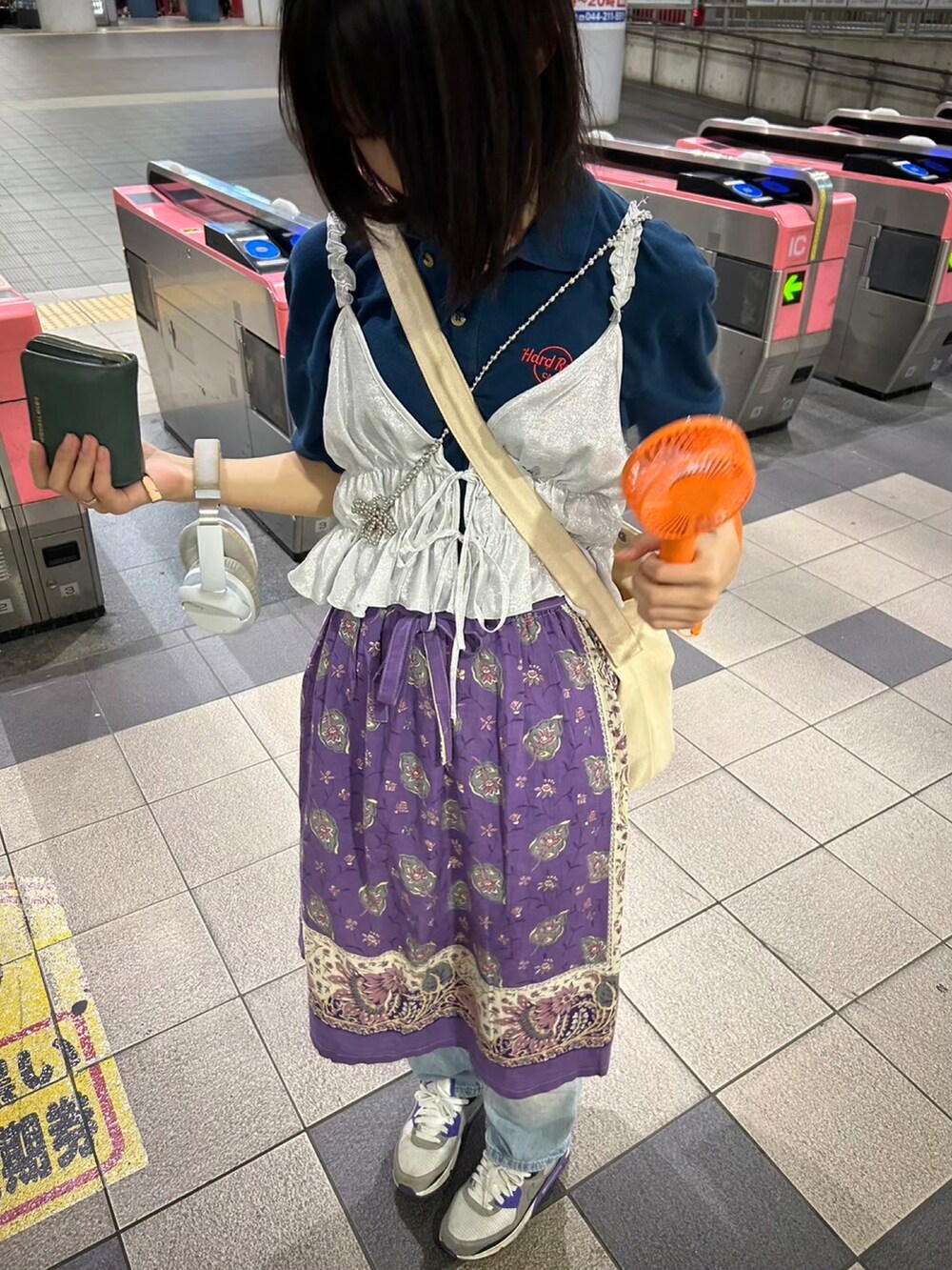 パープル系のスニーカー、シルバー系のキャミソール、ブルー系のポロシャツを着用したレディースの夏コーディネートの2枚目の写真