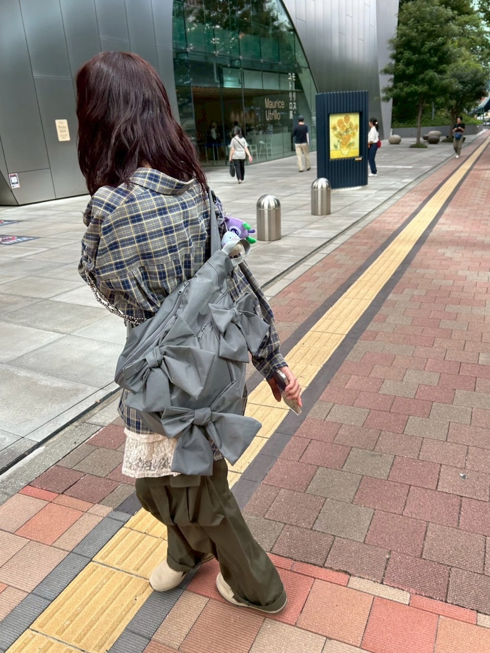 ベージュ系のスニーカー、ブルー系のシャツ/ブラウス、グレー系のショルダーバッグを着用したレディースの秋コーディネートの2枚目の写真