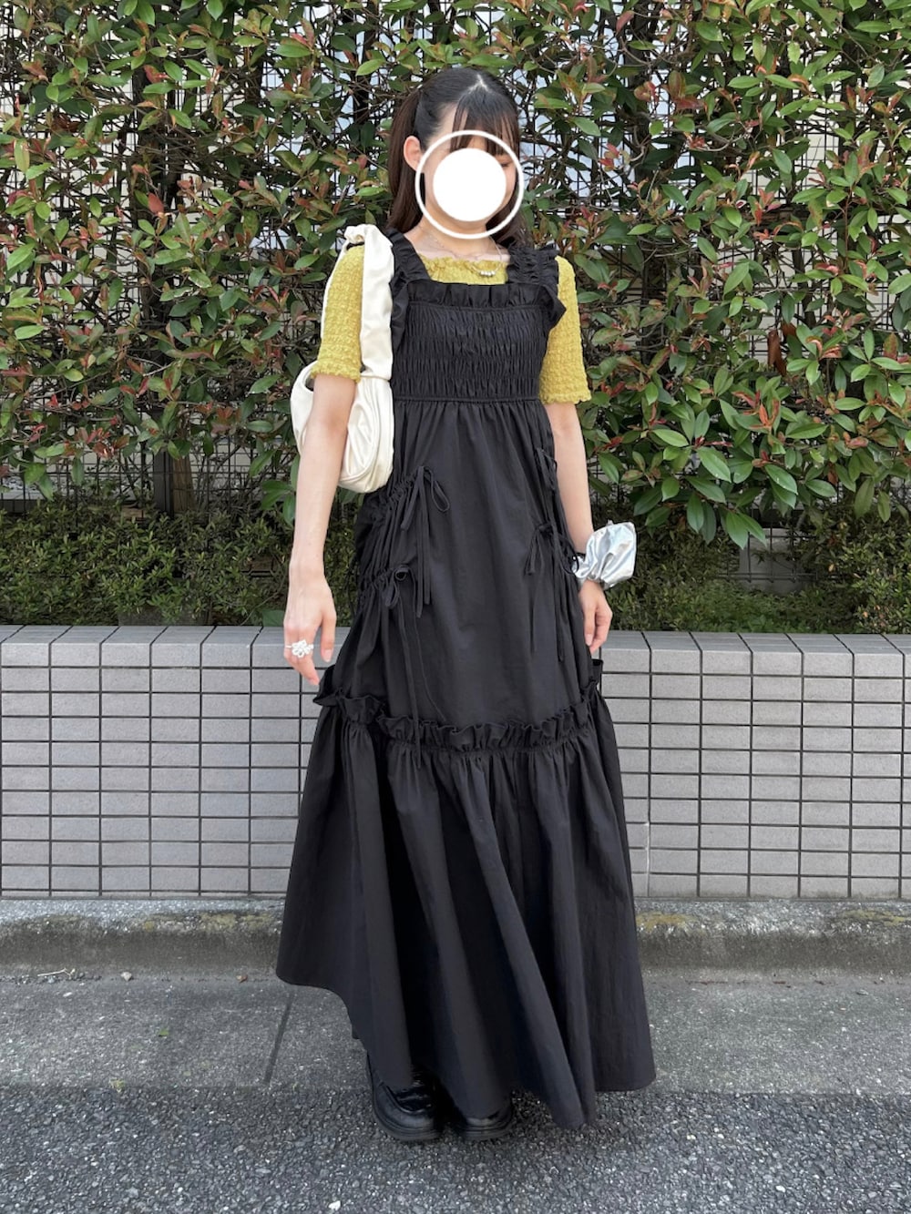 ブラック系のワンピース、イエロー系のTシャツ/カットソー、ブラック系のローファーを着用したレディースの夏コーディネートの2枚目の写真