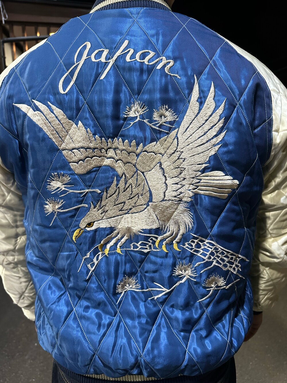 ブルー系のスカジャン、ホワイト系のタンクトップ、ブルー系のデニムパンツを着用したメンズの冬コーディネートの2枚目の写真