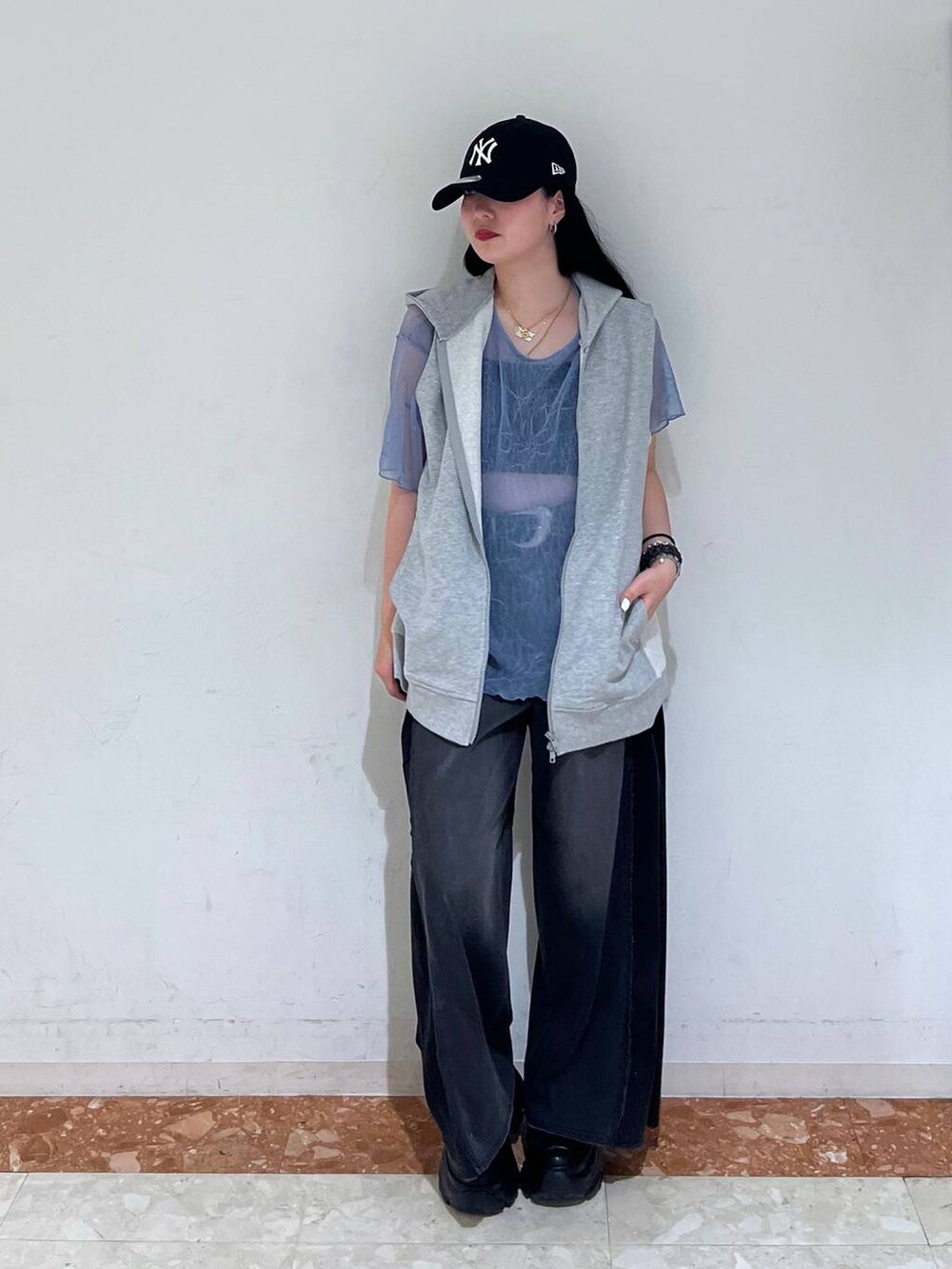 ブラック系のスニーカー、ブラック系のデニムパンツ、グレー系のパーカーを着用したレディースの夏コーディネートの5枚目の写真