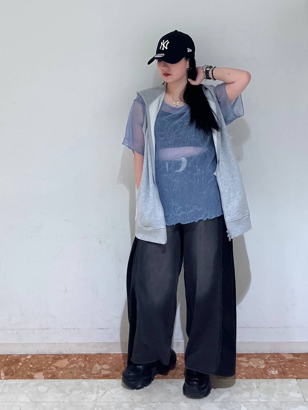 ブラック系のスニーカー、ブラック系のデニムパンツ、グレー系のパーカーを着用したレディースの夏コーディネートの3枚目の写真