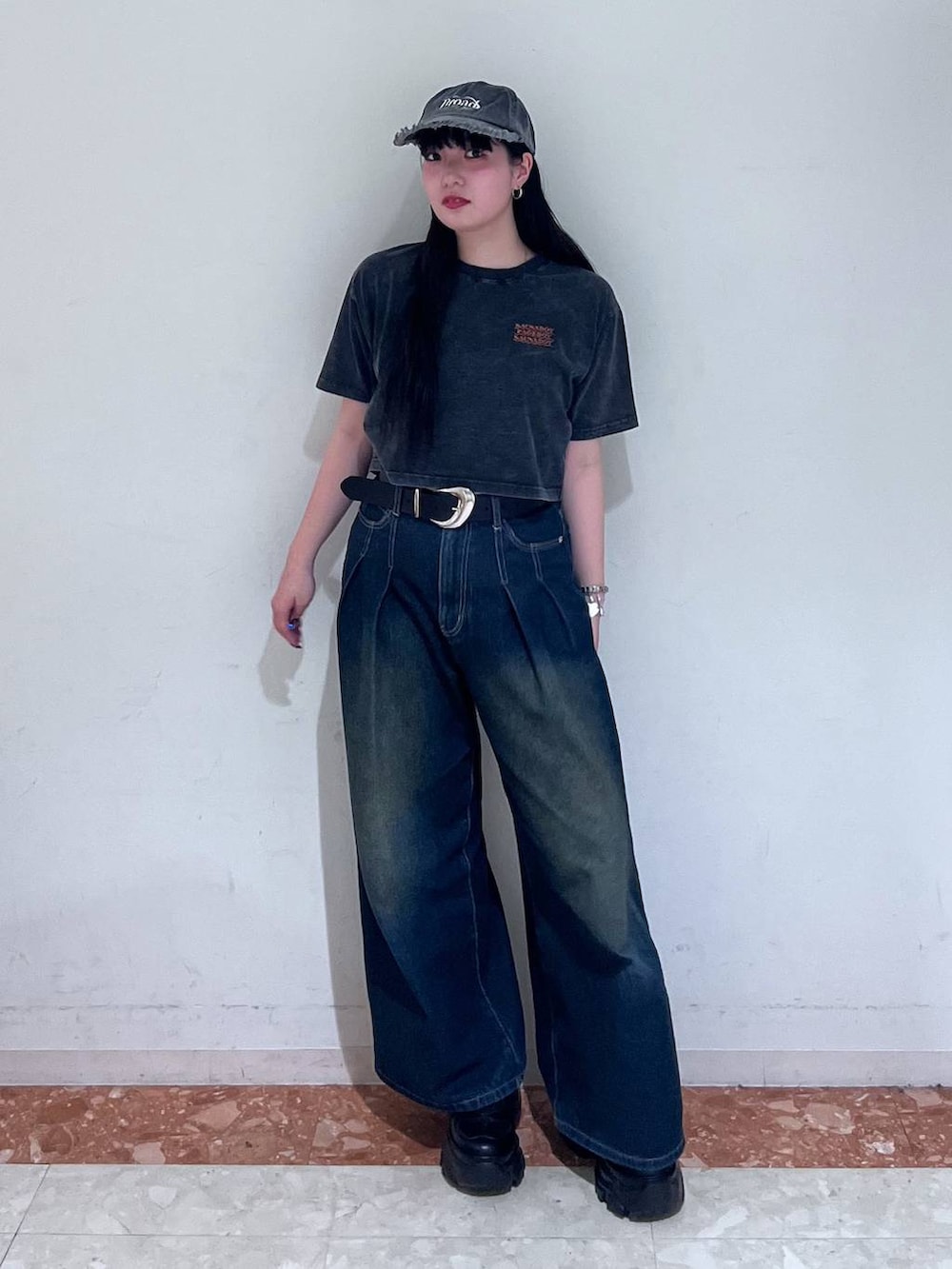 ブラック系のスニーカー、ブルー系のデニムパンツ、ブラック系のTシャツ/カットソーを着用したレディースの春コーディネートの4枚目の写真