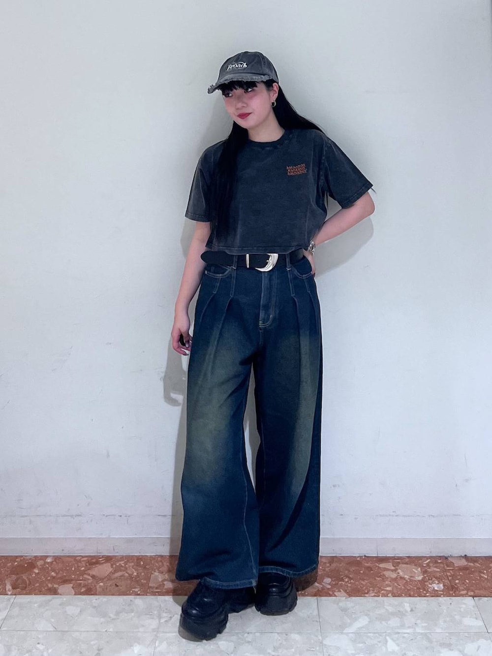 ブラック系のスニーカー、ブルー系のデニムパンツ、ブラック系のTシャツ/カットソーを着用したレディースの春コーディネートの2枚目の写真