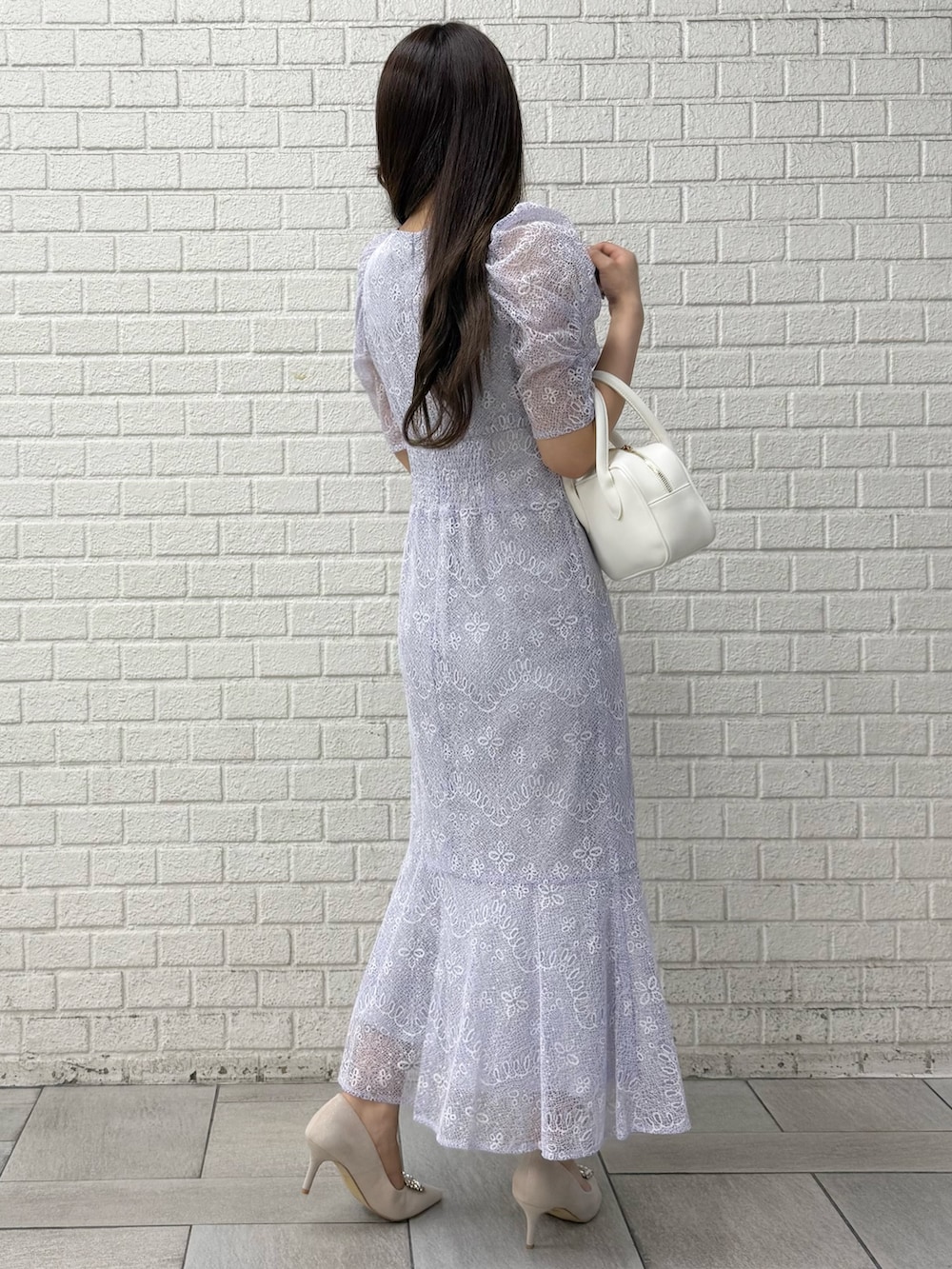 ベージュ系のパンプス、ホワイト系のハンドバッグ、パープル系のドレスを着用したレディースの秋コーディネートの3枚目の写真