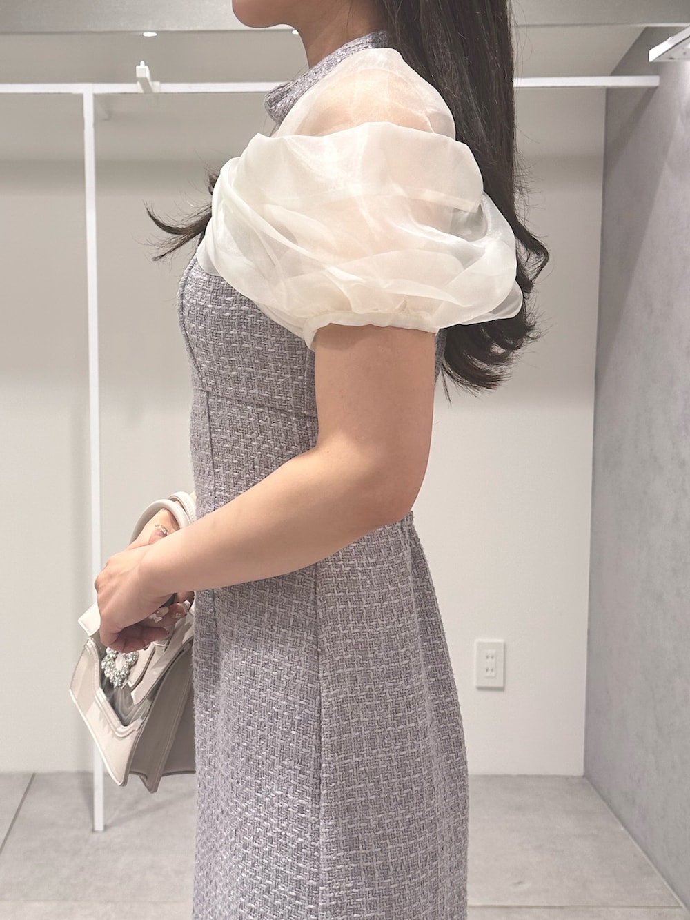 パープル系のワンピース、ホワイト系のパンプス、ベージュ系のショルダーバッグを着用したレディースの夏コーディネートの5枚目の写真