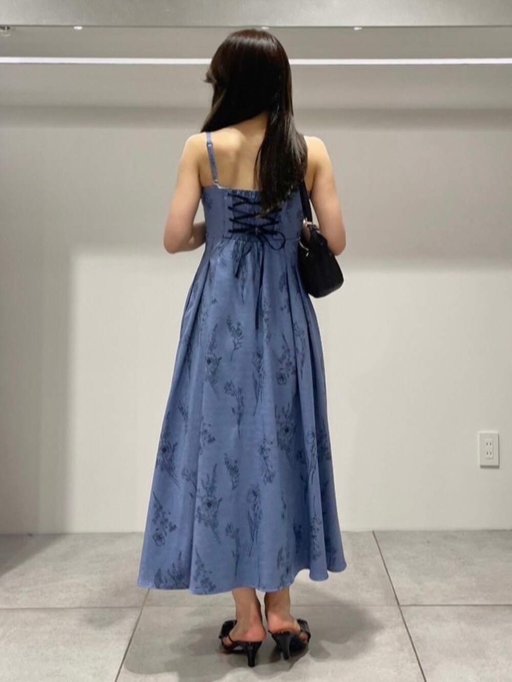 ブルー系のワンピース、ブラック系のサンダル、ブラック系のショルダーバッグを着用したレディースの夏コーディネートの3枚目の写真