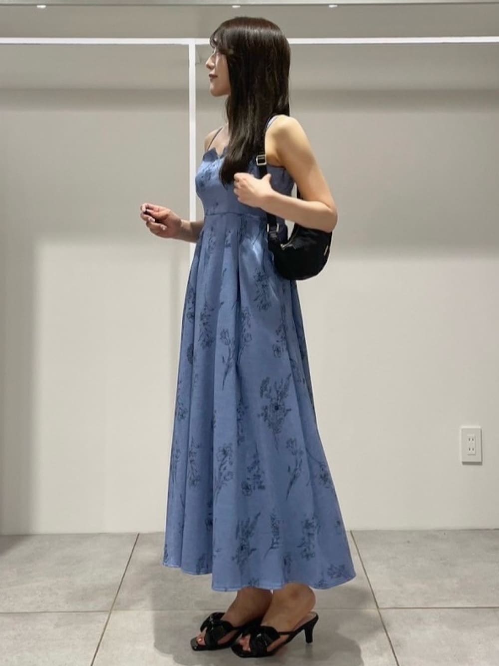 ブルー系のワンピース、ブラック系のサンダル、ブラック系のショルダーバッグを着用したレディースの夏コーディネートの2枚目の写真