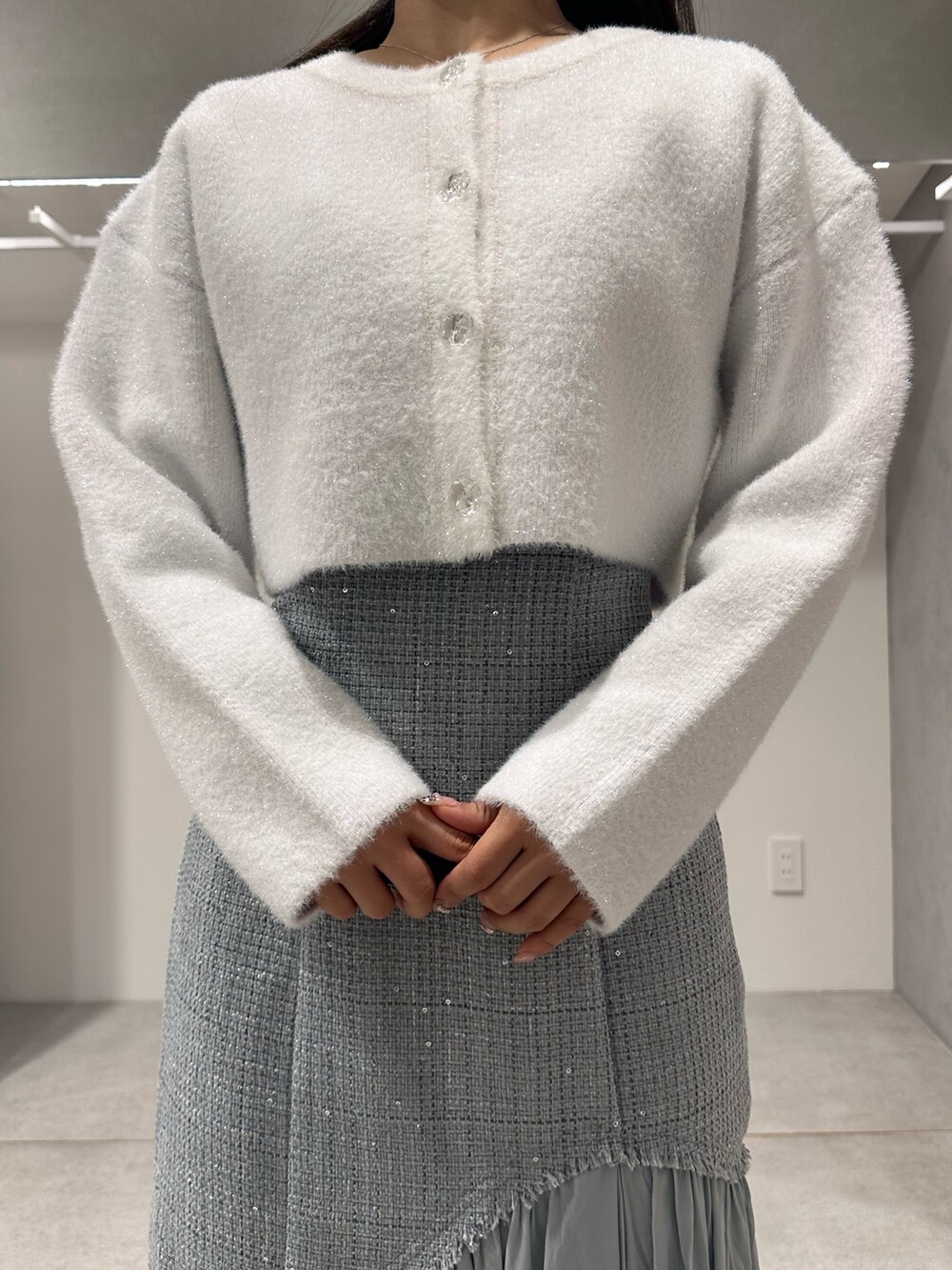 ホワイト系のカーディガン/ボレロ、ブラウン系のハンドバッグ、グリーン系のスカートを着用したレディースの秋コーディネートの4枚目の写真