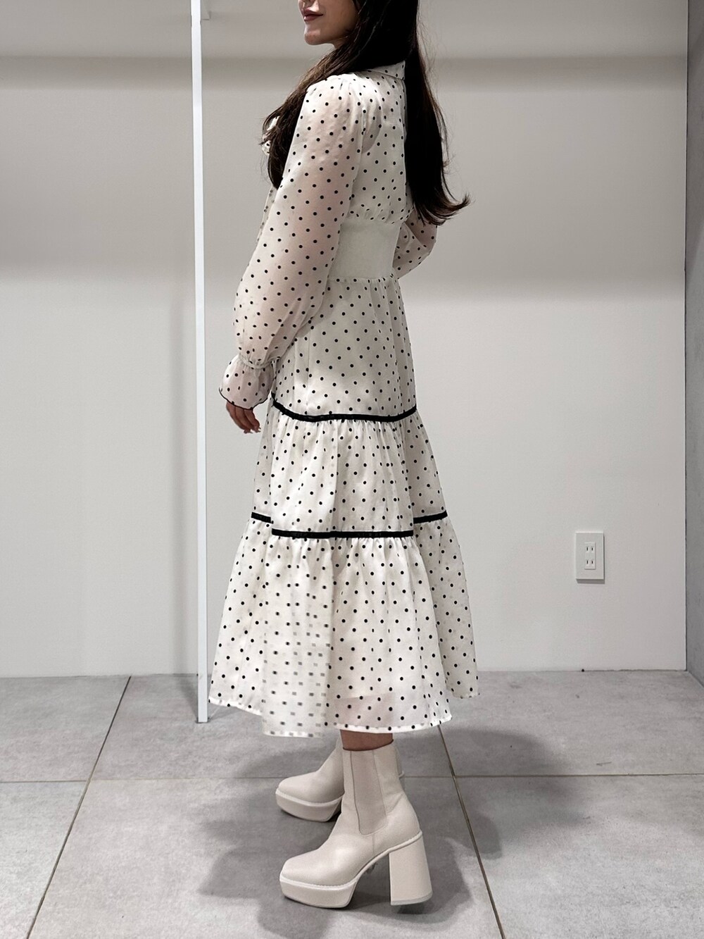 ホワイト系のブーツ、ホワイト系のワンピースを着用したレディースの冬コーディネートの2枚目の写真