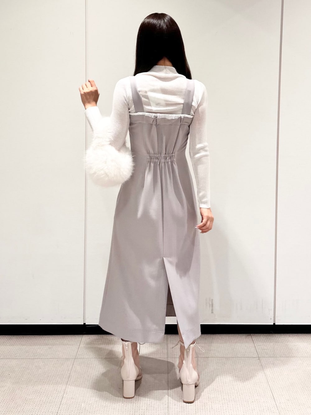 ホワイト系のハンドバッグ、グレー系のワンピース、ホワイト系のブーツを着用したレディースの秋コーディネートの3枚目の写真