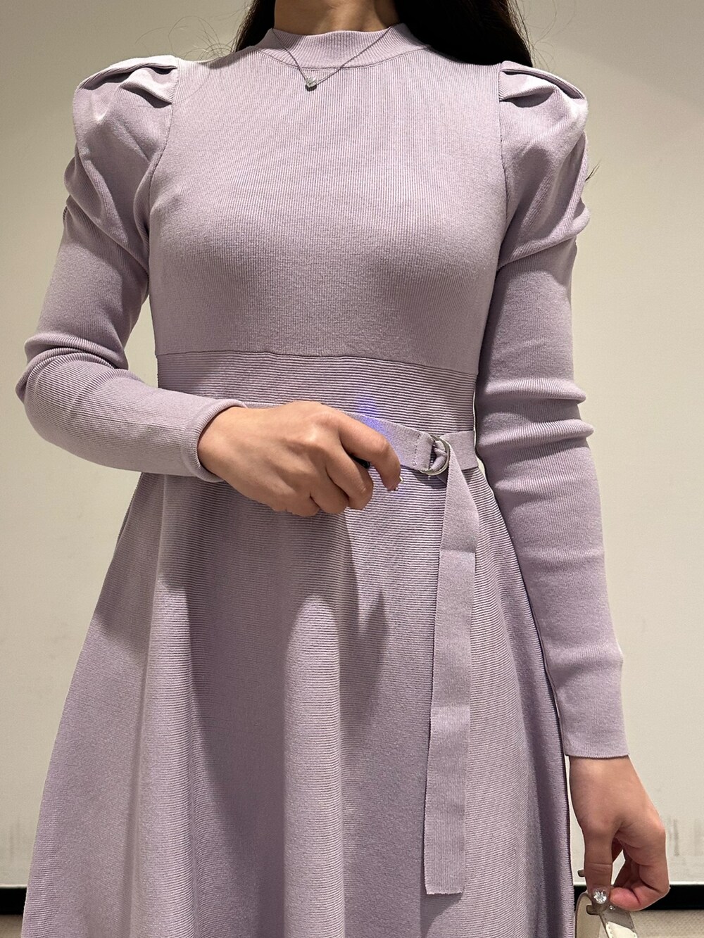 ホワイト系のハンドバッグ、パープル系のワンピース、ホワイト系のブーツを着用したレディースの冬コーディネートの4枚目の写真