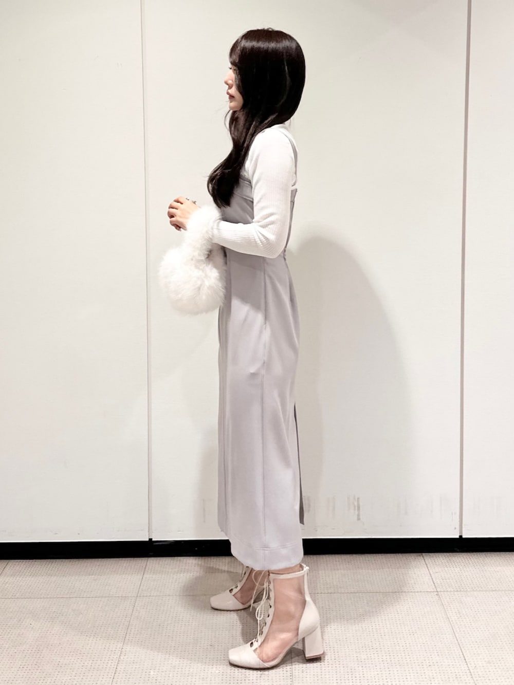 ホワイト系のハンドバッグ、グレー系のワンピース、ホワイト系のブーツを着用したレディースの秋コーディネートの2枚目の写真