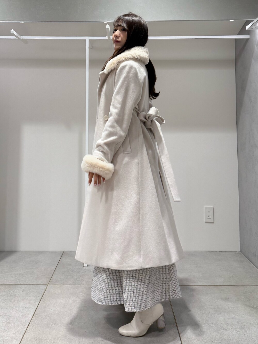 ホワイト系のその他アウター、ホワイト系のニット/セーター、ホワイト系のスカートを着用したレディースの冬コーディネートの2枚目の写真