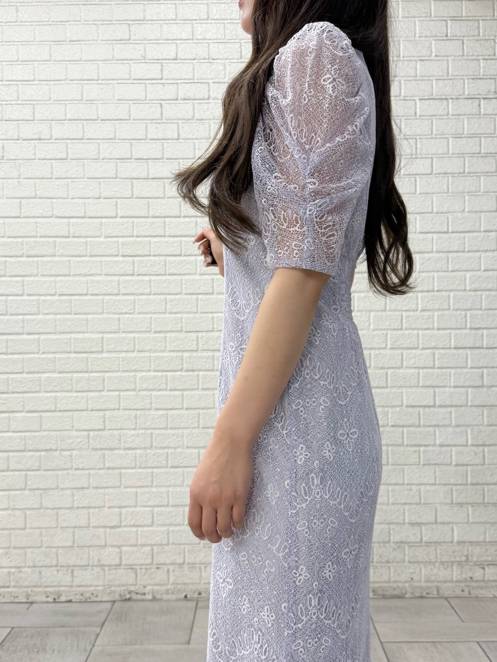 ベージュ系のパンプス、ホワイト系のハンドバッグ、パープル系のドレスを着用したレディースの秋コーディネートの5枚目の写真