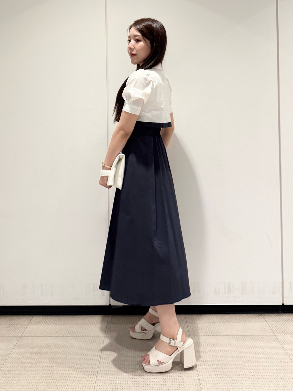 ホワイト系のトートバッグ、ブルー系のワンピース、ホワイト系のサンダルを着用したレディースの夏コーディネートの2枚目の写真