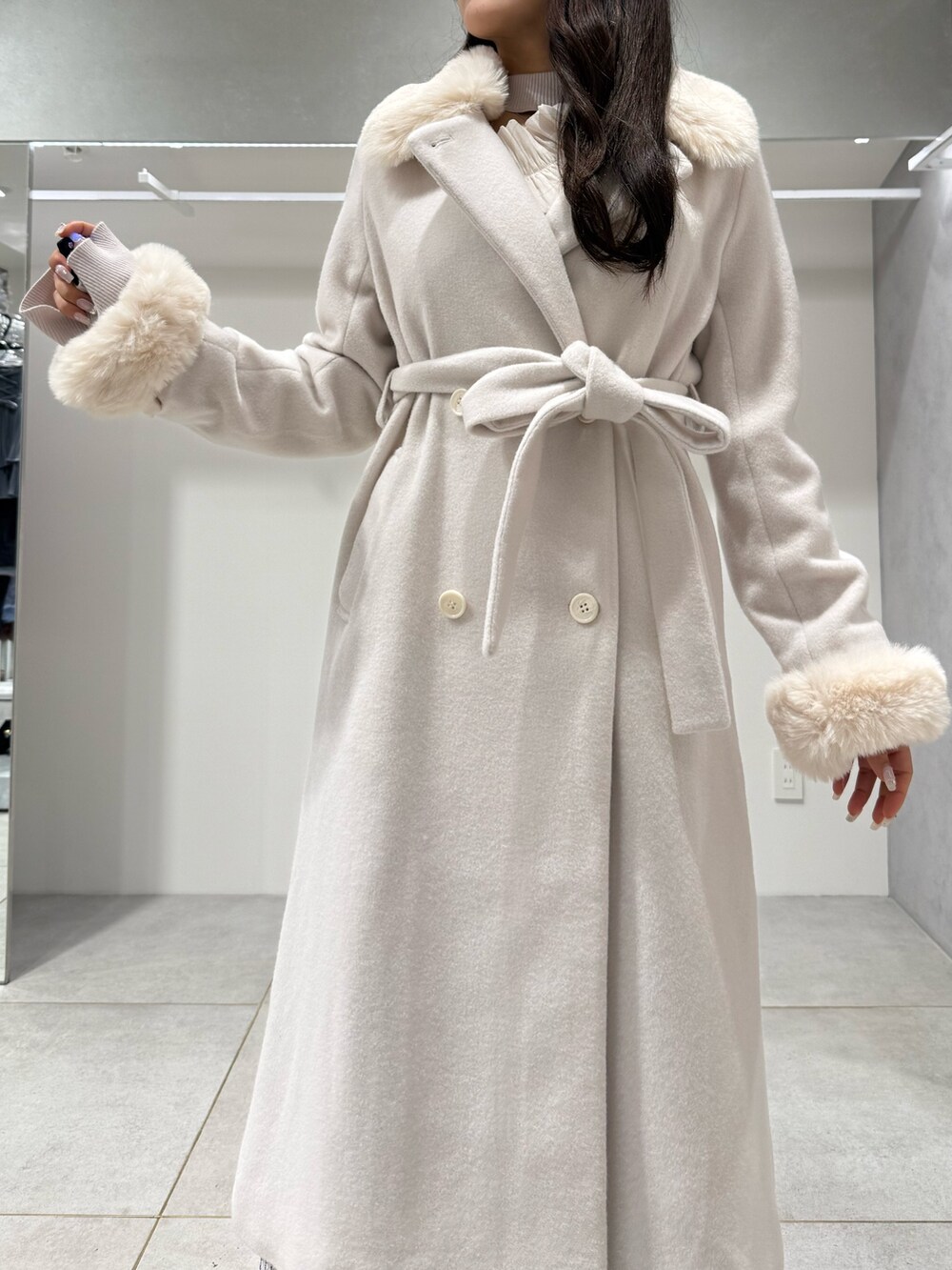 ホワイト系のその他アウター、ホワイト系のニット/セーター、ホワイト系のスカートを着用したレディースの冬コーディネートの4枚目の写真