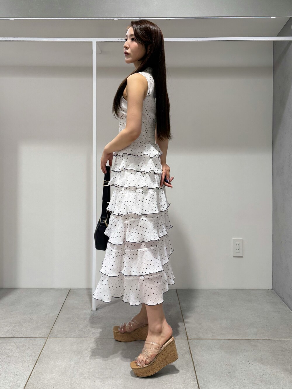 ブラック系のハンドバッグ、その他のサンダル、その他のワンピースを着用したレディースの夏コーディネートの2枚目の写真