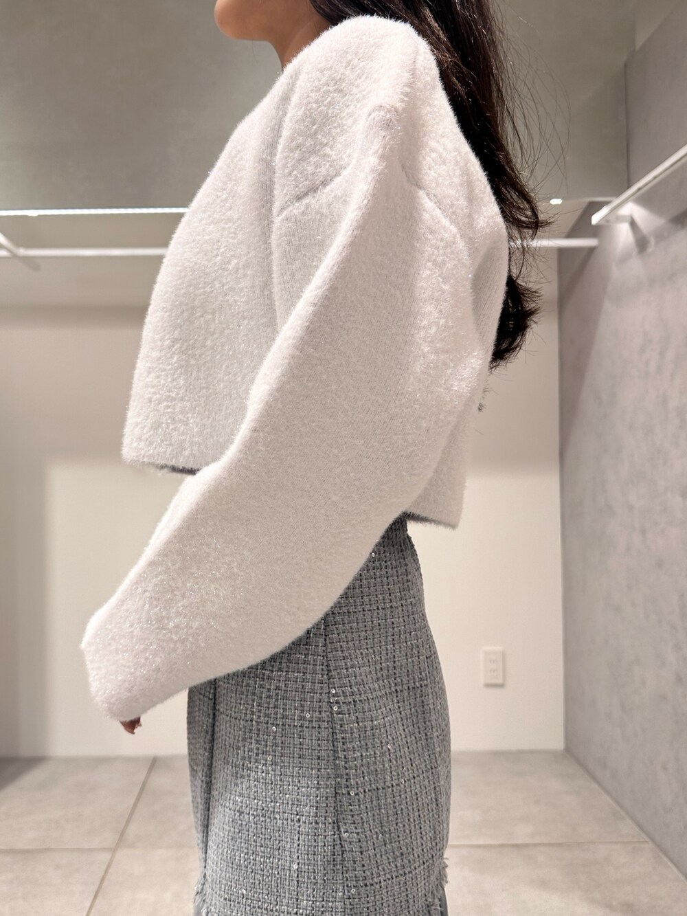 ホワイト系のカーディガン/ボレロ、ブラウン系のハンドバッグ、グリーン系のスカートを着用したレディースの秋コーディネートの5枚目の写真