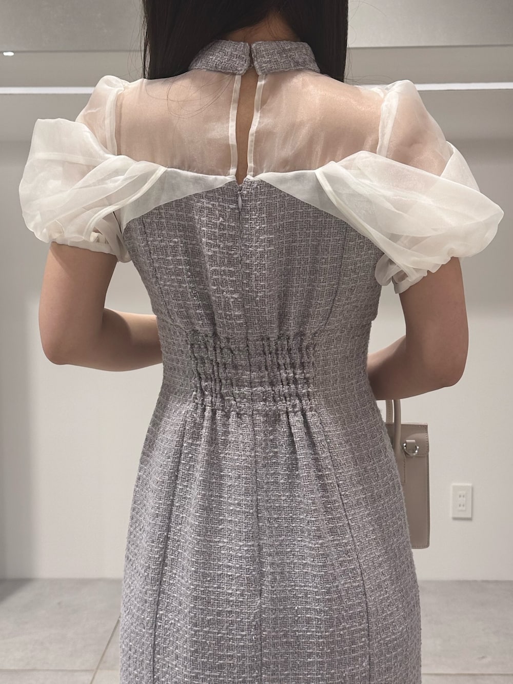 パープル系のワンピース、ホワイト系のパンプス、ベージュ系のショルダーバッグを着用したレディースの夏コーディネートの6枚目の写真