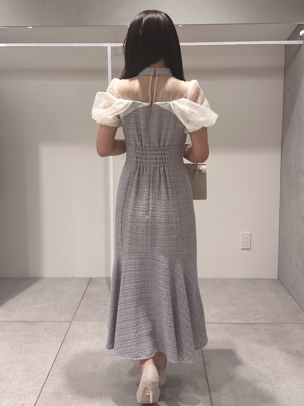 パープル系のワンピース、ホワイト系のパンプス、ベージュ系のショルダーバッグを着用したレディースの夏コーディネートの3枚目の写真