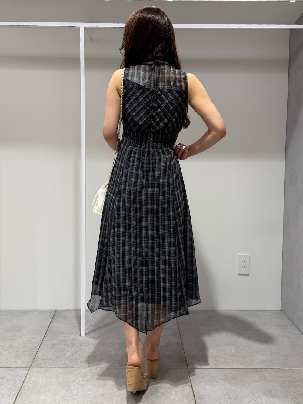 ブラック系のワンピース、ホワイト系のハンドバッグ、その他のサンダルを着用したレディースの夏コーディネートの3枚目の写真