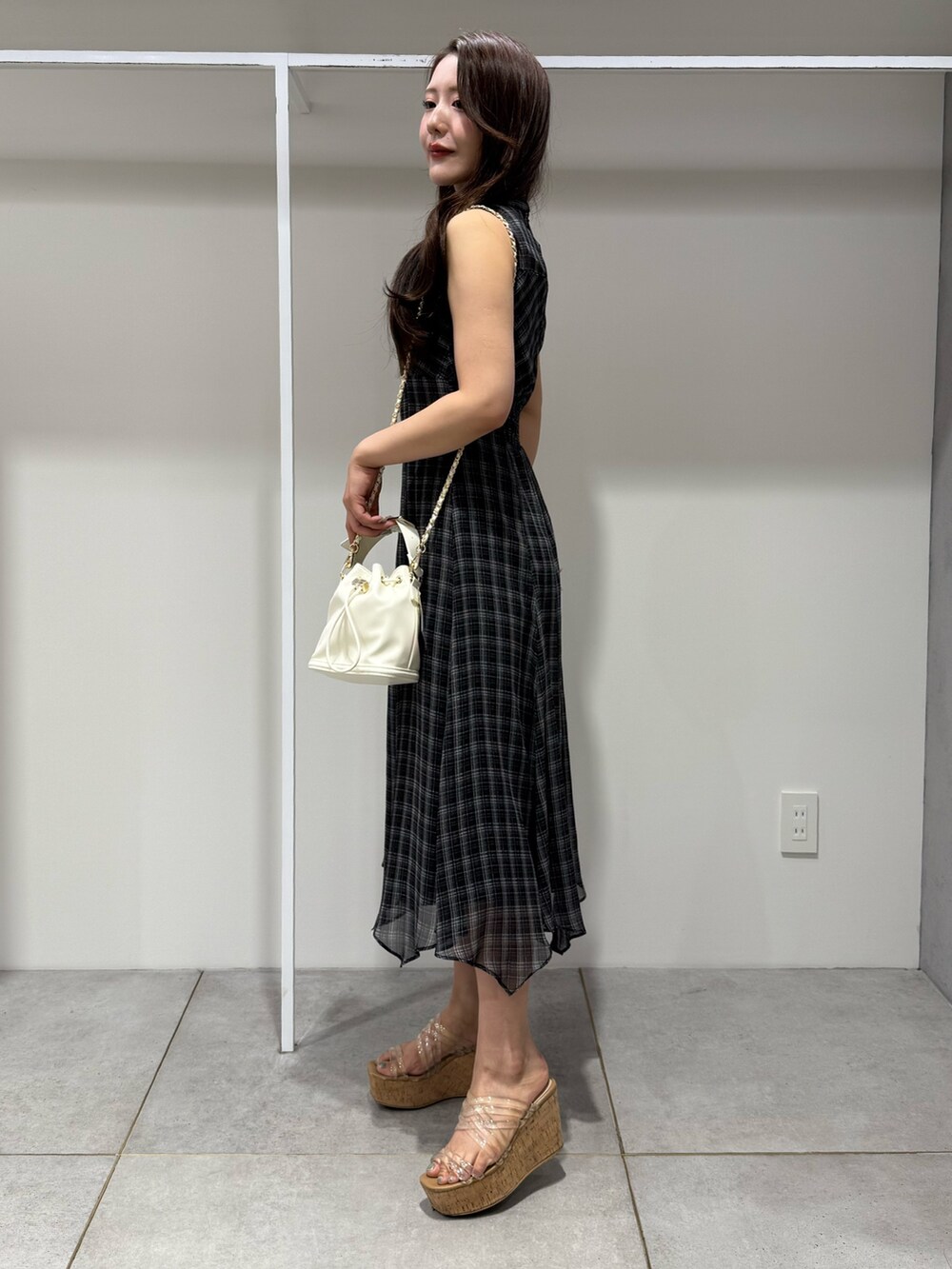 ブラック系のワンピース、ホワイト系のハンドバッグ、その他のサンダルを着用したレディースの夏コーディネートの2枚目の写真