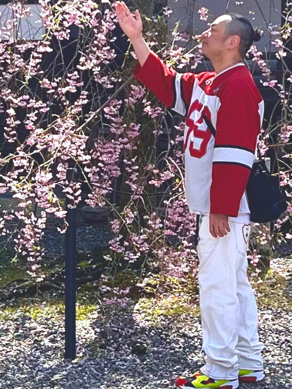 レッド系のその他トップス、ホワイト系のデニムパンツ、イエロー系のスニーカーを着用したメンズの夏コーディネートの2枚目の写真