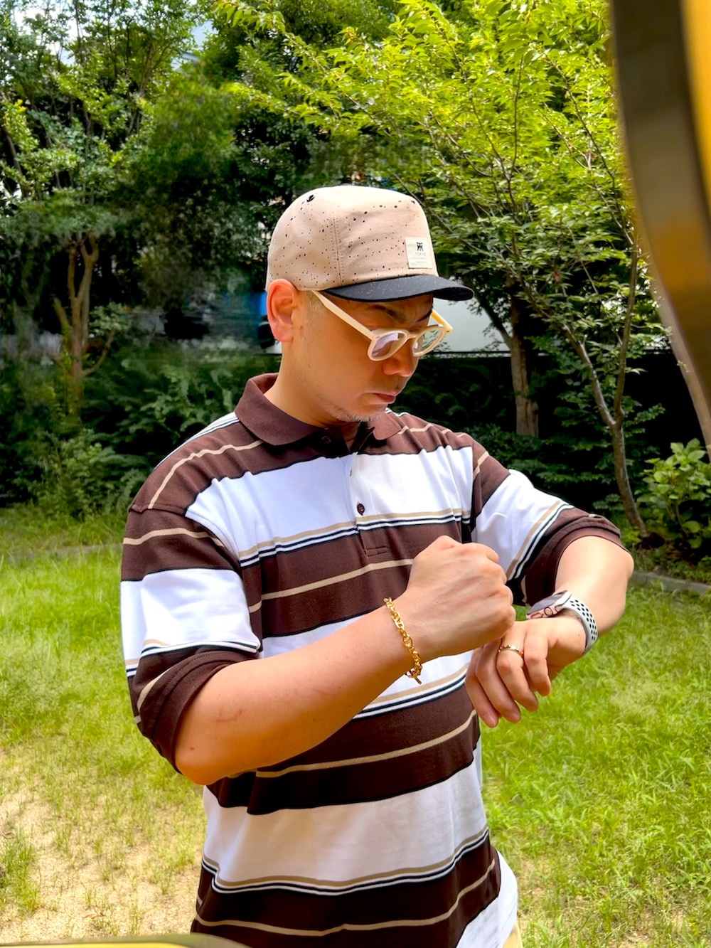 ベージュ系のその他パンツ、ブラウン系のポロシャツ、ブラウン系のスニーカーを着用したメンズの夏コーディネートの2枚目の写真