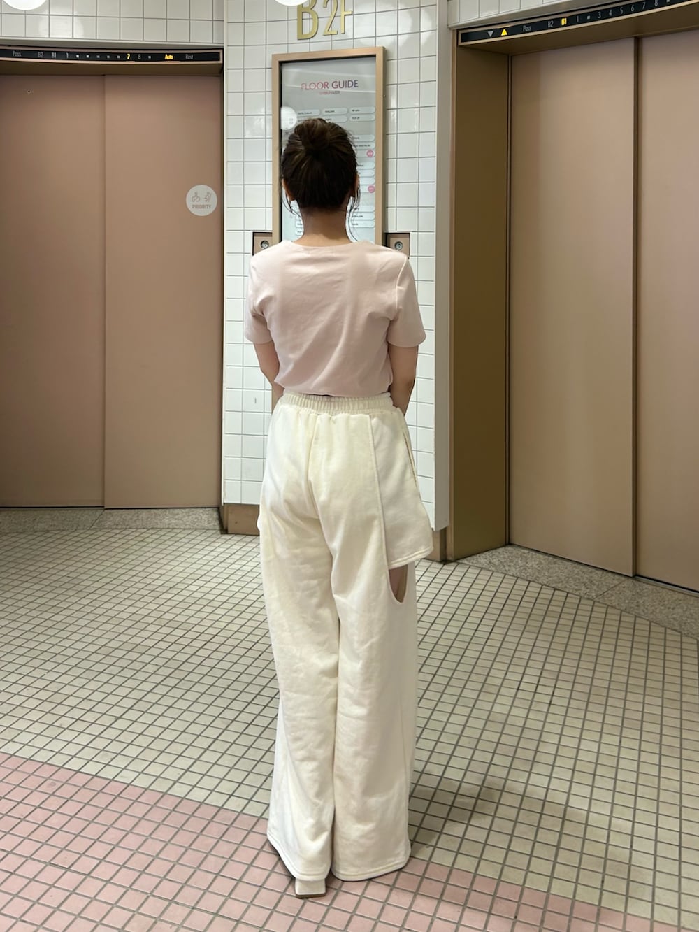 ホワイト系のパンツ、ピンク系のTシャツ/カットソー、ブラウン系のショルダーバッグを着用したレディースの春コーディネートの6枚目の写真