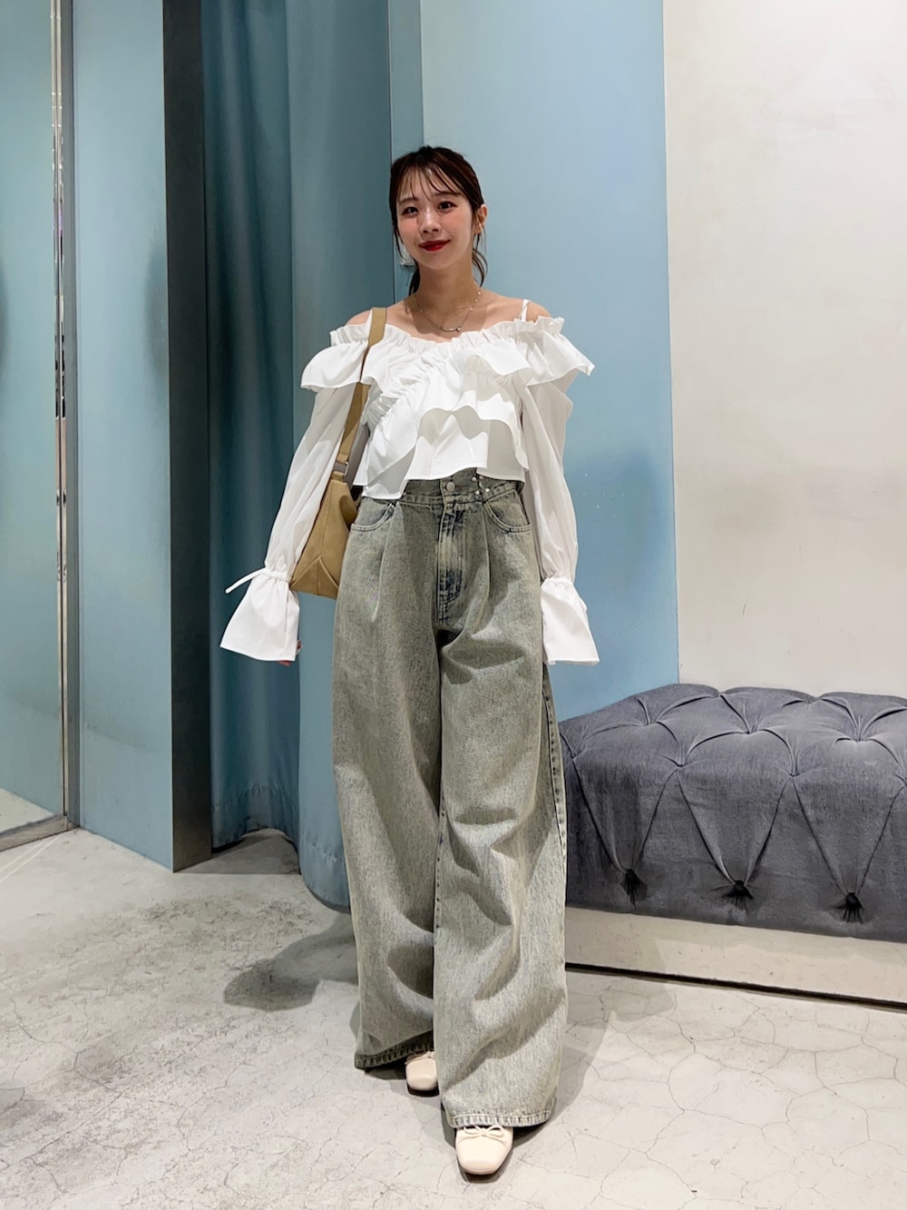 ブルー系のデニムパンツ、ホワイト系のシャツ/ブラウス、ベージュ系のショルダーバッグを着用したレディースの春コーディネートの3枚目の写真