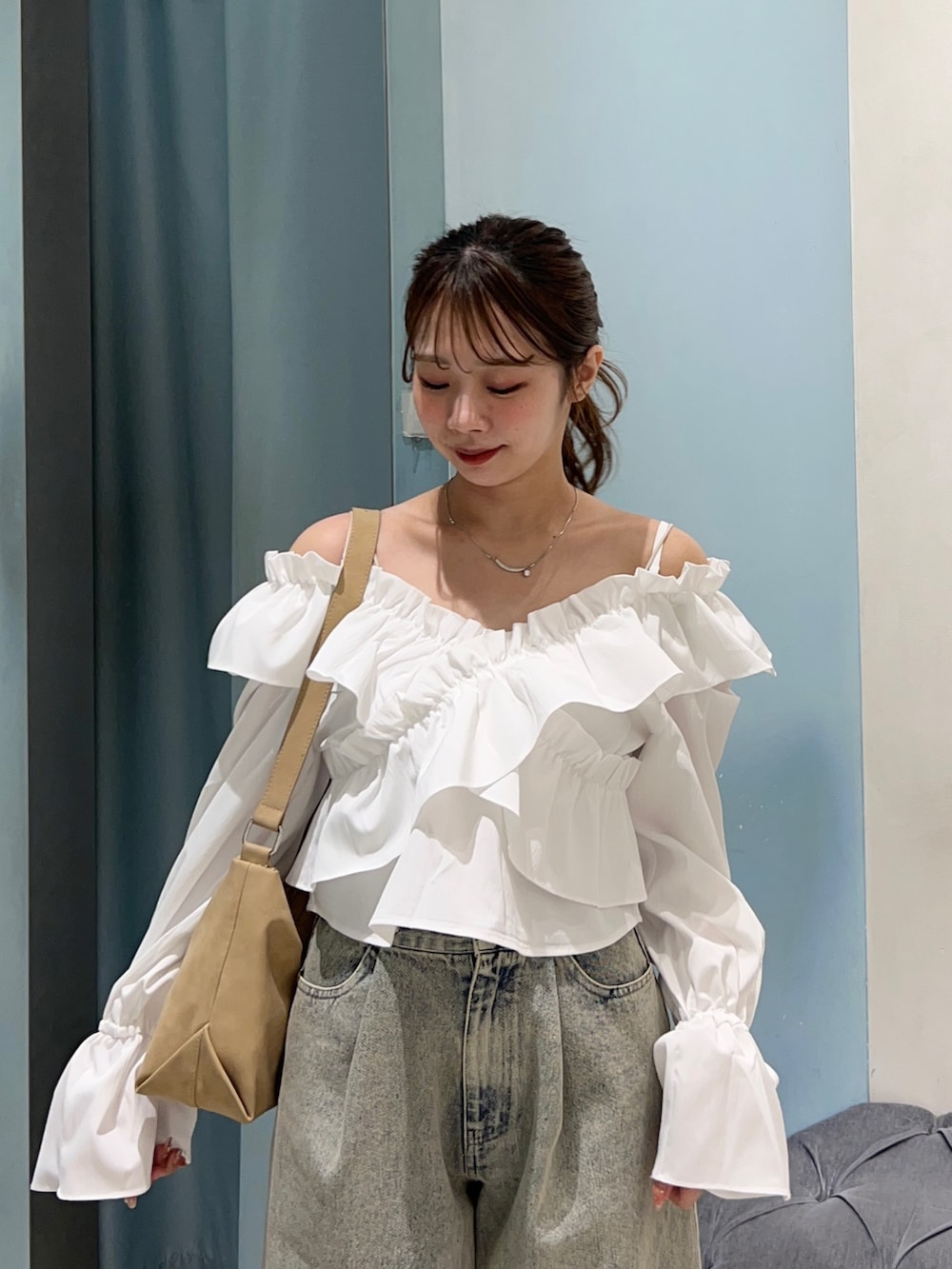 ブルー系のデニムパンツ、ホワイト系のシャツ/ブラウス、ベージュ系のショルダーバッグを着用したレディースの春コーディネートの4枚目の写真