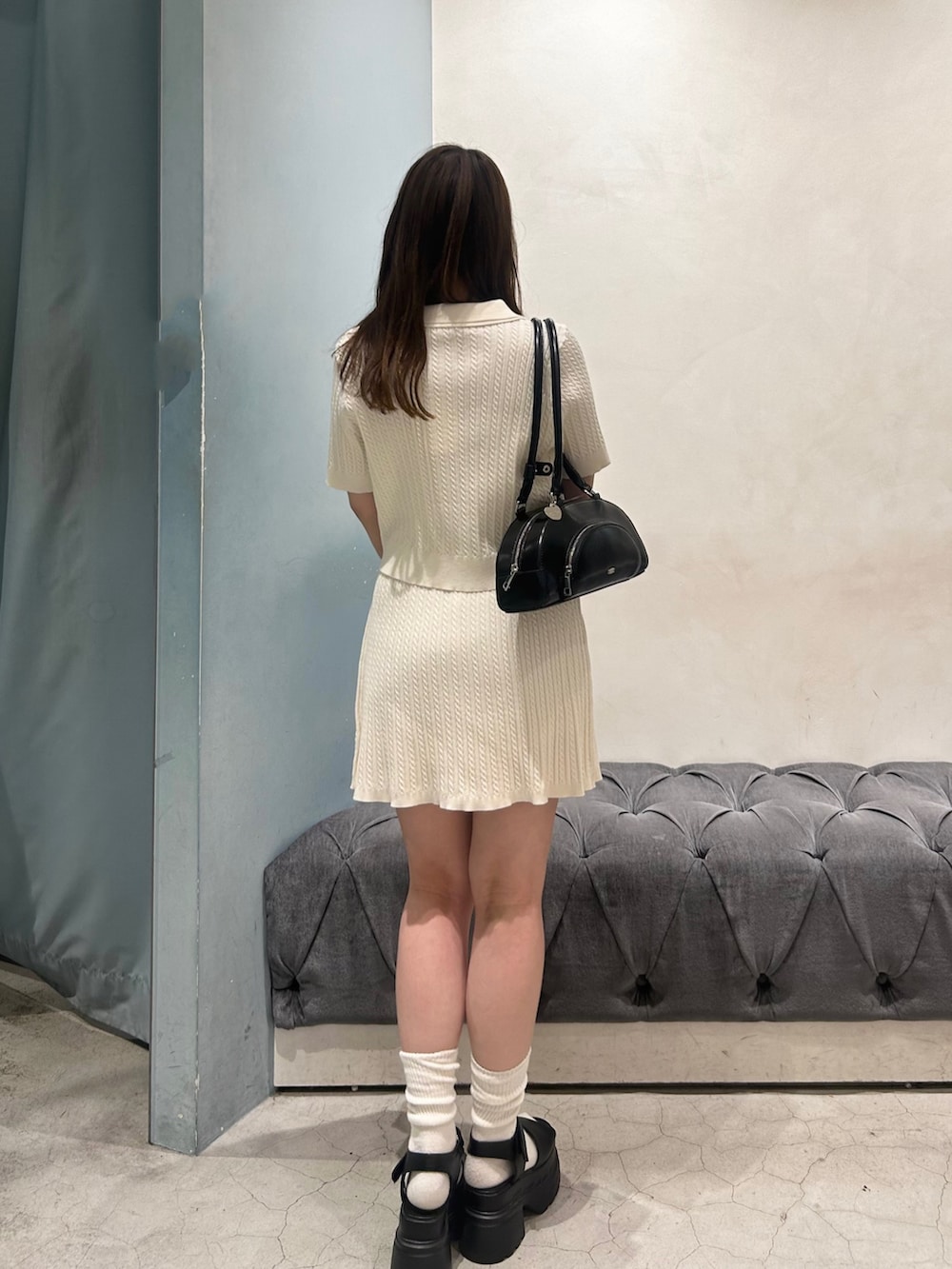 ホワイト系のスカート、ホワイト系のニット/セーター、ブラック系のボストンバッグを着用したレディースの春コーディネートの4枚目の写真