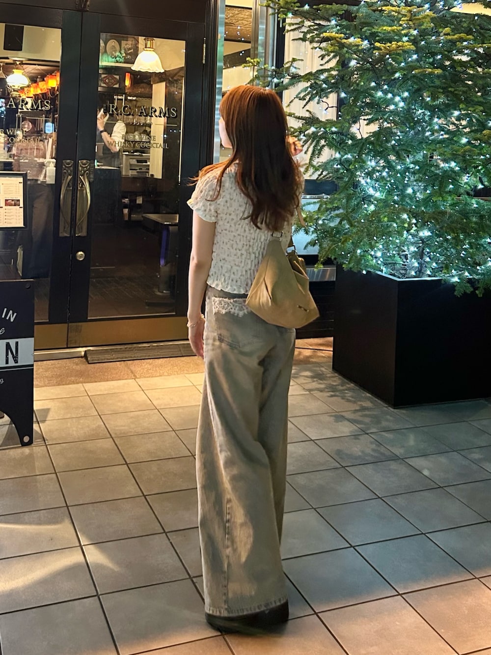 ブルー系のデニムパンツ、ホワイト系のTシャツ/カットソー、ベージュ系のショルダーバッグを着用したレディースの夏コーディネートの6枚目の写真