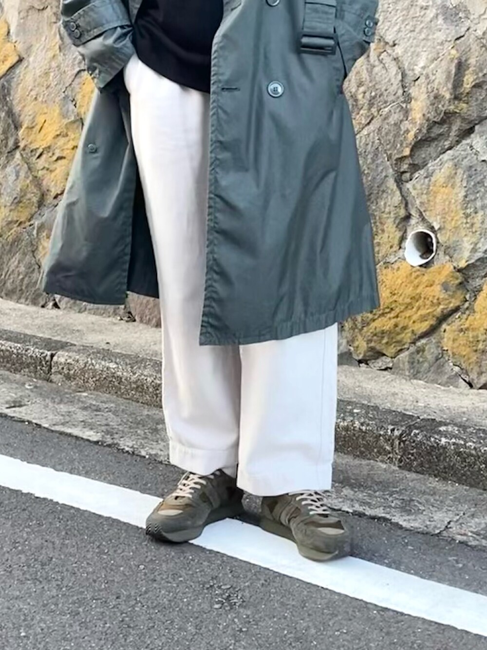 ホワイト系のデニムパンツ、グリーン系のスニーカー、ブラウン系のメガネを着用したメンズの冬コーディネートの2枚目の写真