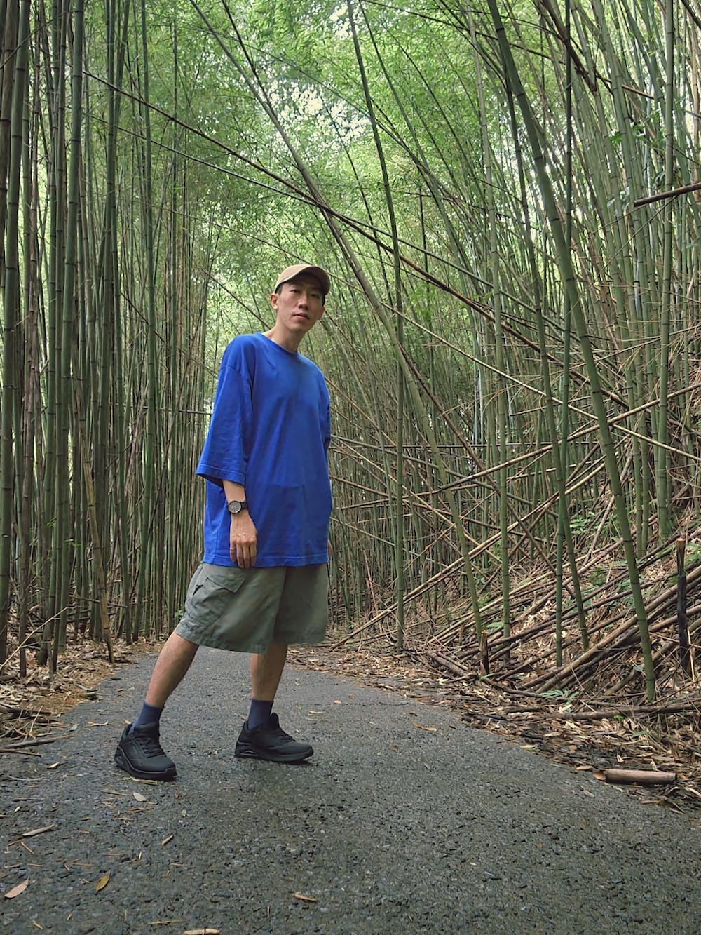 ブラック系のスニーカー、グリーン系のカーゴパンツ、ブルー系のTシャツ/カットソーを着用したメンズの夏コーディネートの2枚目の写真