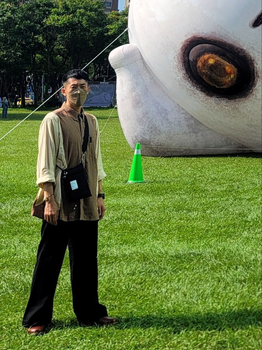 ブラック系のスラックス、ベージュ系のシャツ/ブラウス、ブラック系のショルダーバッグを着用したメンズの夏コーディネートの2枚目の写真