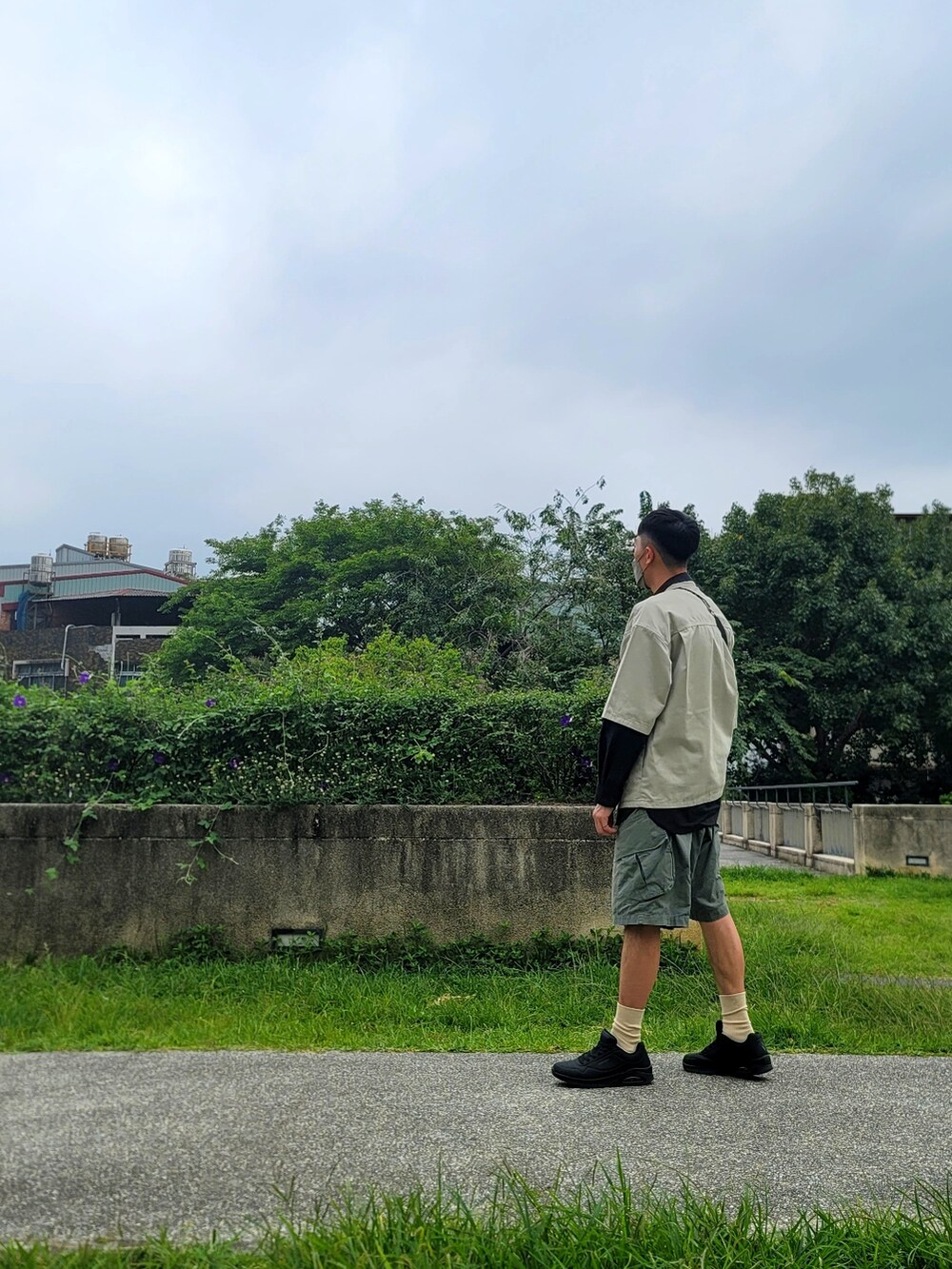 グリーン系のカーゴパンツ、ブラック系のスニーカー、ブラック系のシャツ/ブラウスを着用したメンズの春コーディネートの5枚目の写真