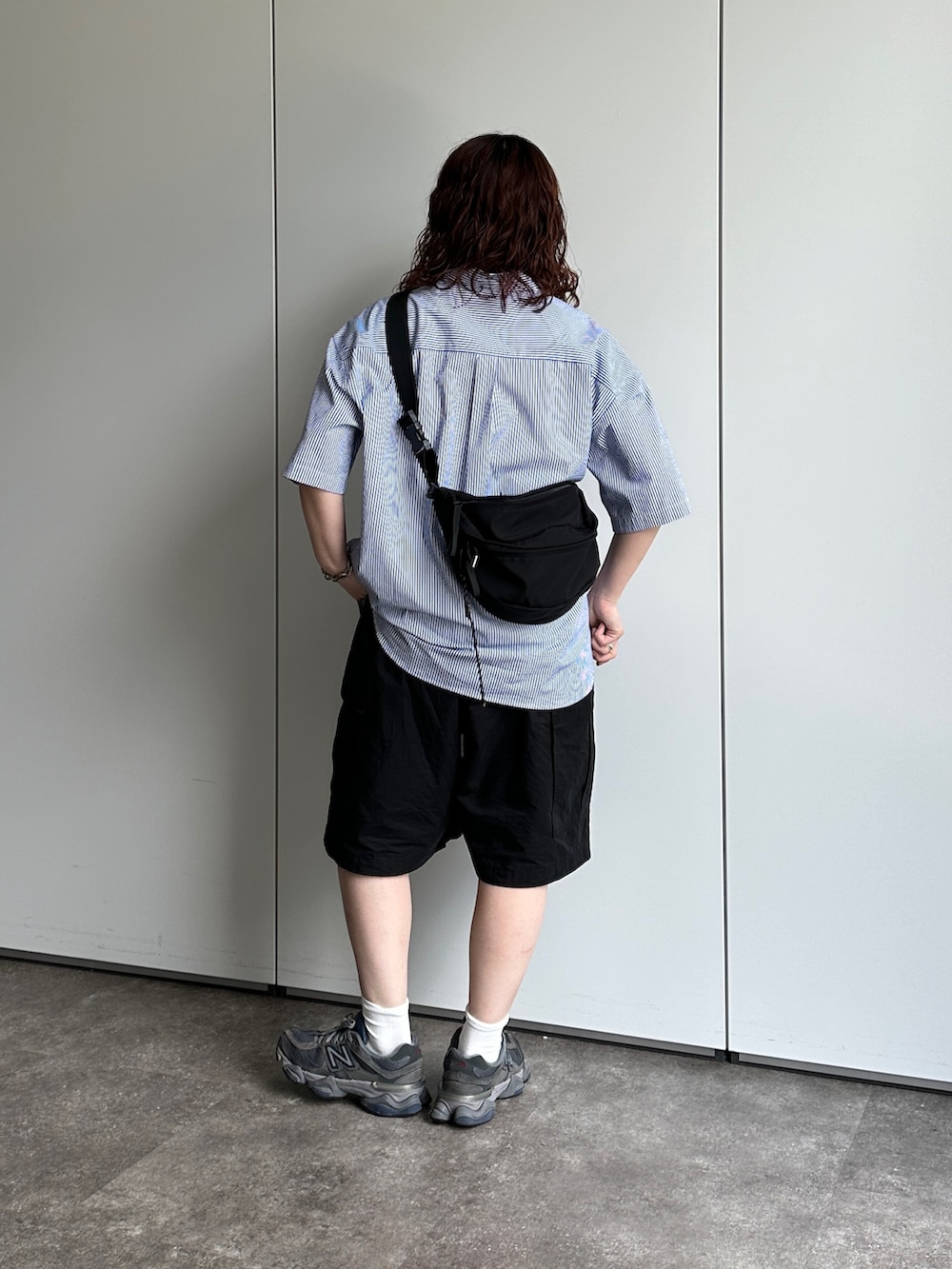 ブラック系のカーゴパンツ、ブラック系のボディバッグ/ウエストポーチ、ブルー系のシャツ/ブラウスを着用したレディースの春コーディネートの2枚目の写真