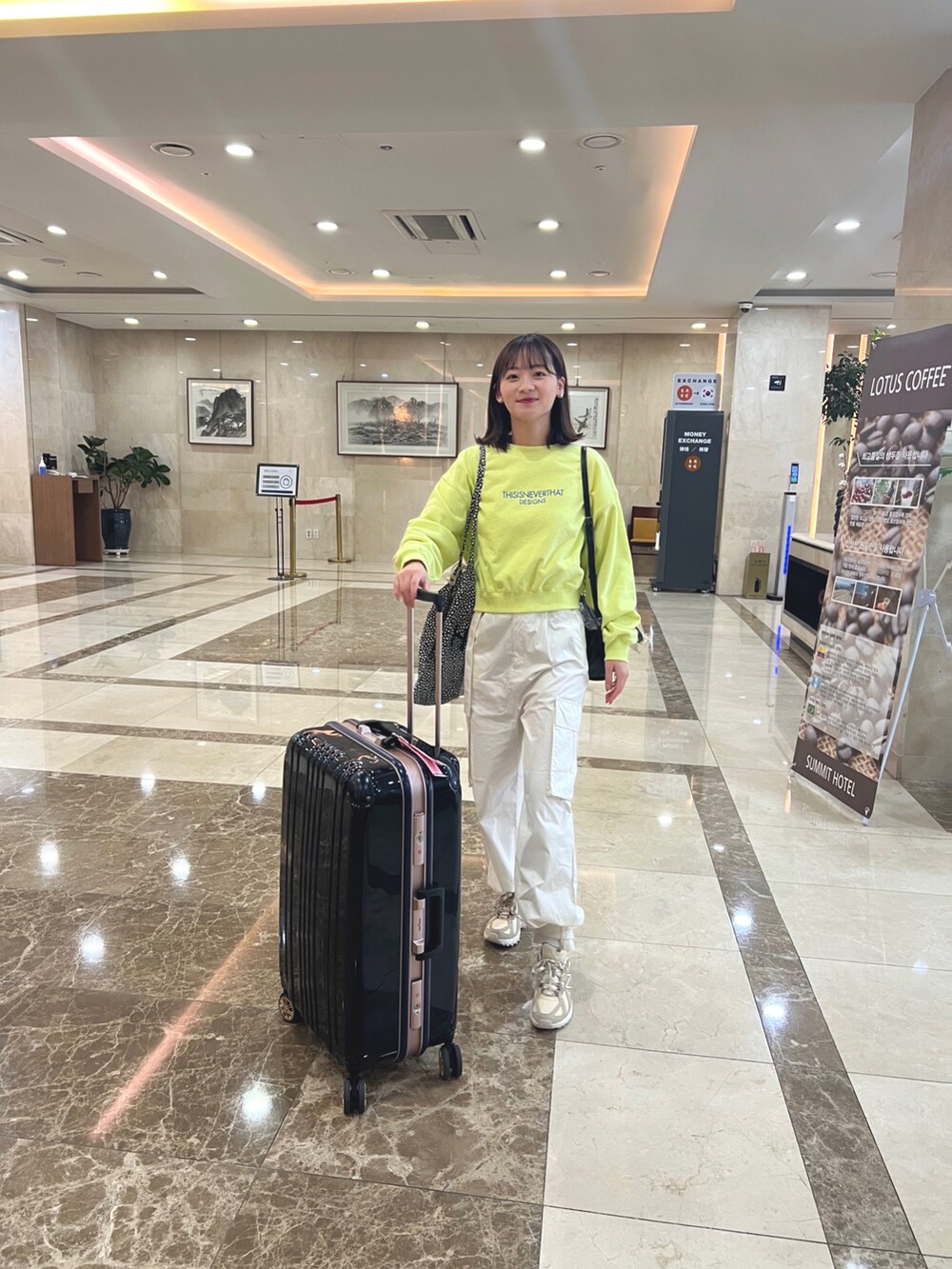 ホワイト系のカーゴパンツ、ベージュ系のスニーカー、イエロー系のトップスを着用したレディースの春コーディネートの2枚目の写真