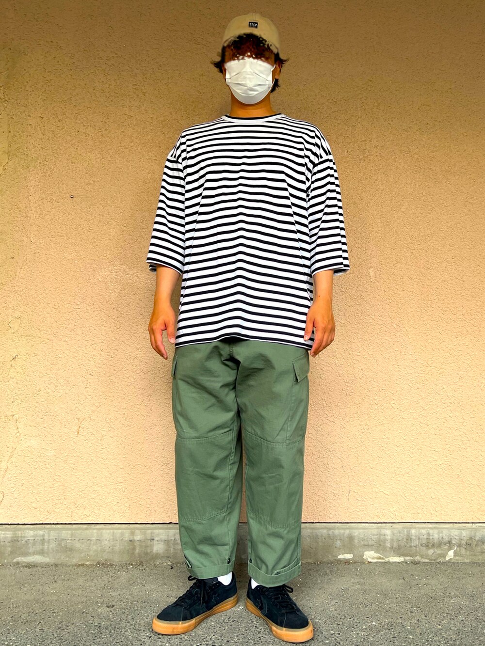 ブラック系のTシャツ/カットソー、グリーン系のカーゴパンツ、ブラック系のスニーカーを着用したメンズの春コーディネートの2枚目の写真