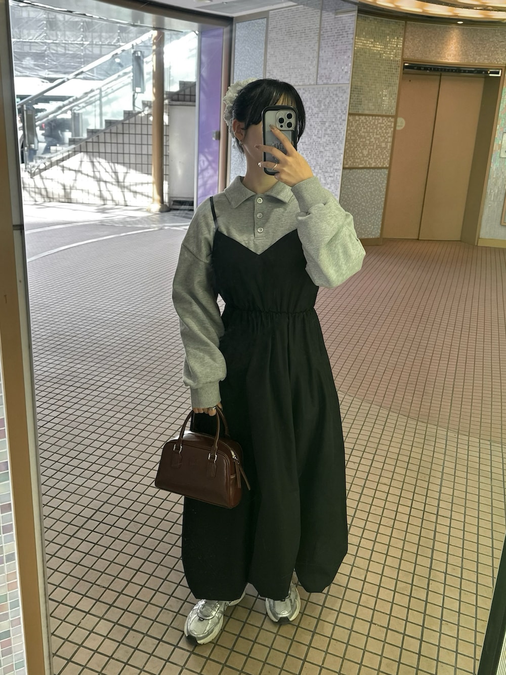 ホワイト系のスニーカー、レッド系のハンドバッグ、ブラック系のワンピース/ドレスを着用したレディースの冬コーディネートの2枚目の写真