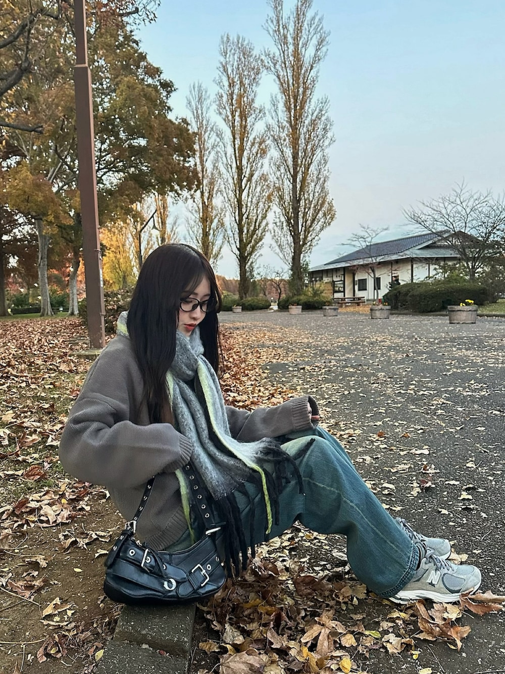 ブルー系のデニムパンツ、グレー系のスニーカー、グレー系のマフラーを着用したレディースの冬コーディネートの2枚目の写真