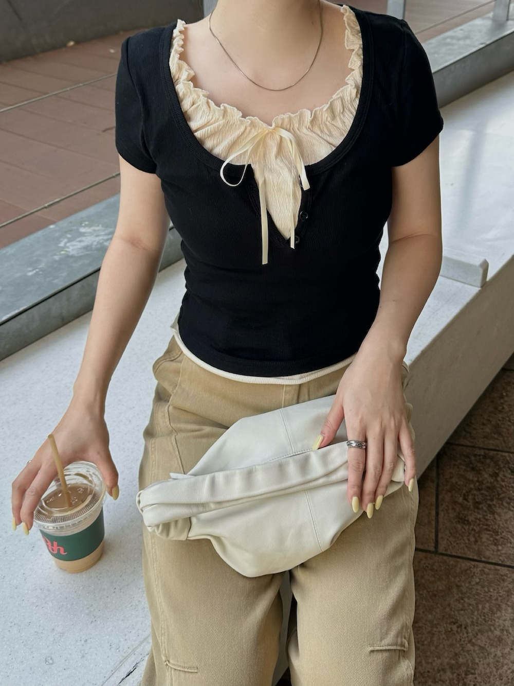 ブラック系のTシャツ/カットソー、ブラック系のローファー、ベージュ系のチノパンツを着用したレディースの春コーディネートの2枚目の写真