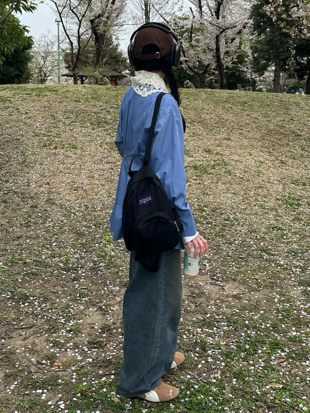 ブルー系のシャツ/ブラウス、ブルー系のデニムパンツ、ブラウン系のスニーカーを着用したレディースの春コーディネートの2枚目の写真