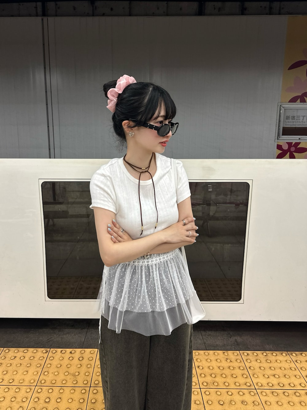 ブラック系のスニーカー、ホワイト系のTシャツ/カットソー、ブラック系のデニムパンツを着用したレディースの夏コーディネートの2枚目の写真