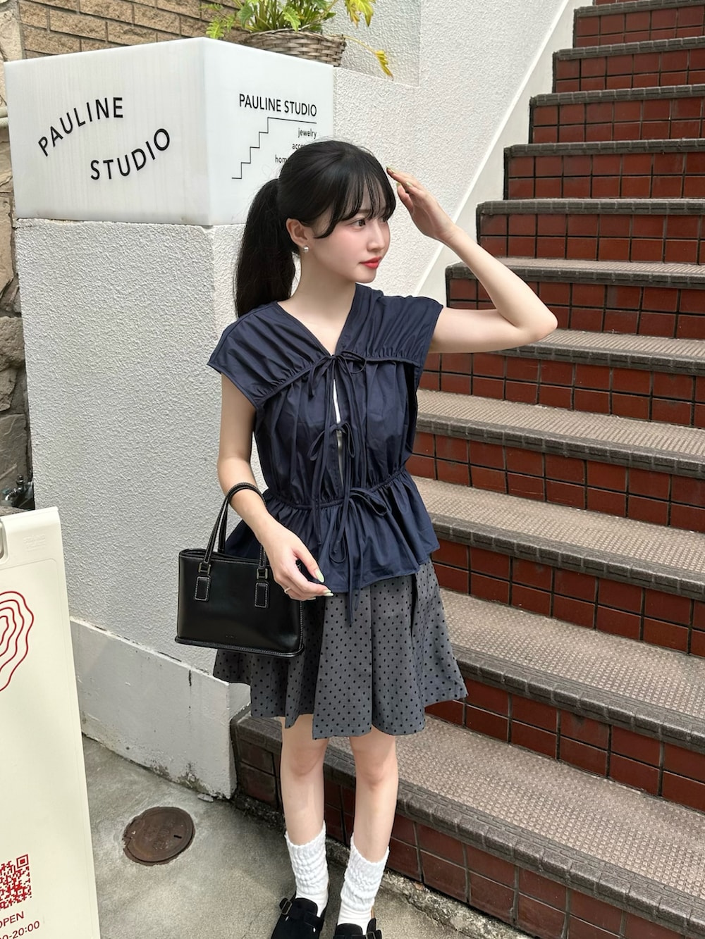 ブルー系のシャツ/ブラウス、グレー系のスカートを着用したレディースの夏コーディネートの2枚目の写真